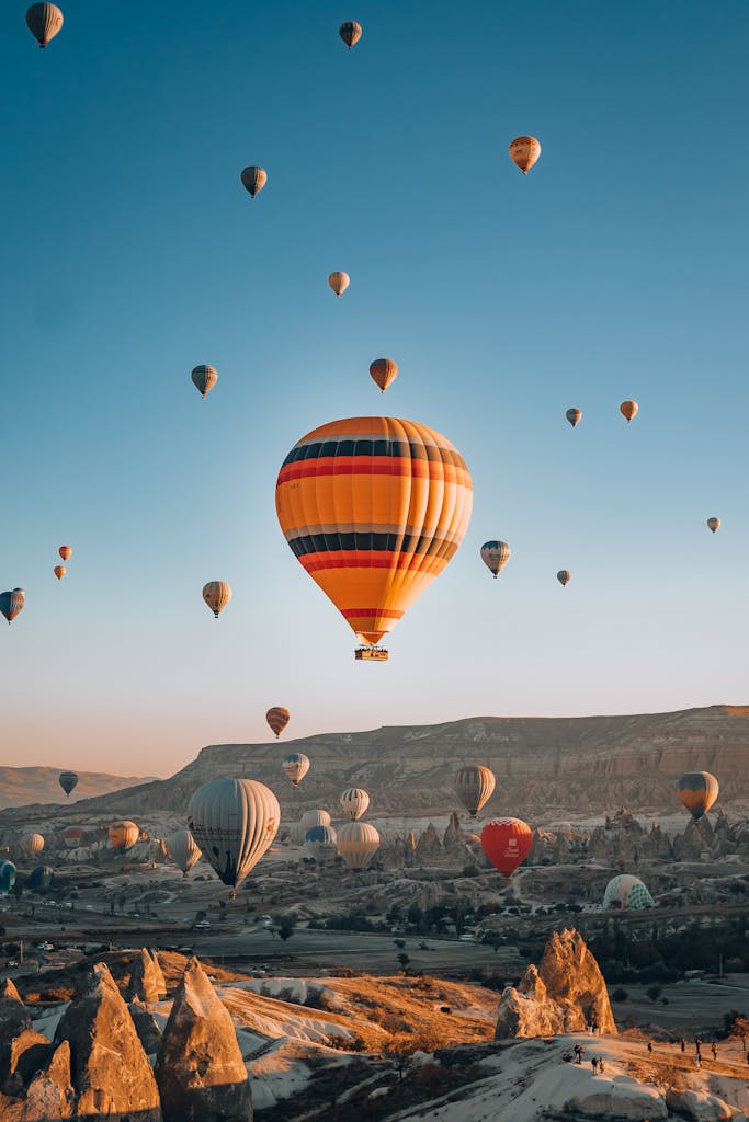 Majestic hot air balloons flying over Cappadocia, Turkey at sunrise, creating a spectacular view.
